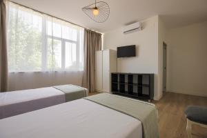 a hotel room with two beds and a tv at Hotel Finca Biazu in Ocaña