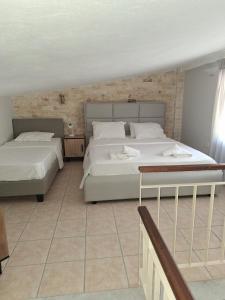 Un dormitorio con dos camas y una pared de ladrillo. en Posidi pool apartment, en Possidi 16 fotos más