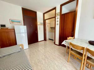 a kitchen and dining room with a table and a refrigerator at Apartment in Porto Santa Margherita 43488 in Porto Santa Margherita di Caorle +7 photos