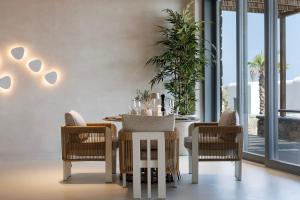 uma sala de jantar com uma mesa e cadeiras brancas em Maximus Mykonos em Platis Yialos Mykonos