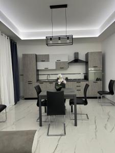 a dining room with a table and chairs and a kitchen at Vitale House in Borgetto +8 photos
