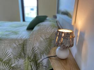 a lamp sitting on a table next to a bed at La Stanza dei Castagni in Villar Focchiardo