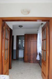 otwarty korytarz z drewnianymi drzwiami i kuchnią w obiekcie Casa Amadora w mieście Carnota