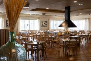 a restaurant with tables and chairs and a vase at Hotel Casa Lorenzo in Villarrobledo