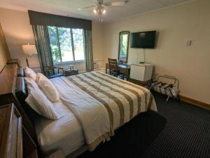 a hotel room with a large bed and a television at Mariner motor hotel in Collingwood +29 photos
