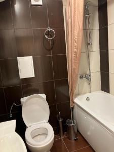 a bathroom with a toilet and a bath tub at Апартамент в КК "Елените" с фронтална гледка море, разположен на самия плаж in Sveti Vlas