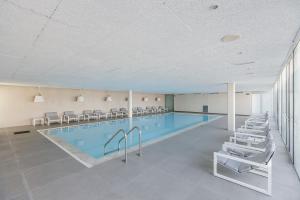 a large swimming pool with chairs and a swimming pool at Troia Design Hotel in Troia