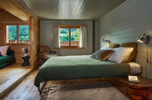 ein Schlafzimmer mit einem Bett und einem Tisch und Fenstern in der Unterkunft Sunneschy in Klosters Serneus