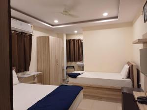 a hotel room with two beds and a bathroom at Sahasra Sree Suites Inn in Hyderabad +27 photos