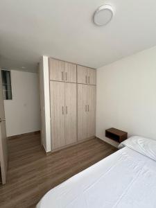a bedroom with a large white bed and a closet at alojamiento en apartamento moderno in Manizales +8 photos