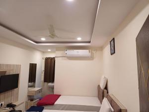 a small room with a bed and a air conditioner at Sahasra Sree Suites Inn in Hyderabad