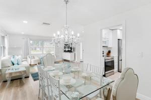 a dining room and living room with a glass table and chairs at Modern Coastal Home in Clearwater Beach