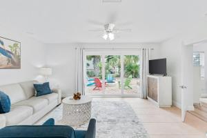 a white living room with a couch and a table at Modern Coastal Home in Clearwater Beach