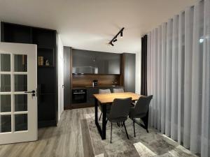 a dining room with a wooden table and chairs at Art superior apartment in Kosovo Polje +13 photos