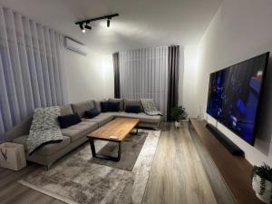 a living room with a couch and a large tv at Art superior apartment in Kosovo Polje