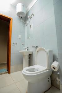a bathroom with a toilet and a sink at Edrin Apartments in Kampala +2 photos