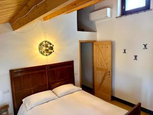 a bedroom with a bed with a wooden headboard at Casa Ancarano Historic Cottage Panoramic position sea 3km 4-8pers in Sirolo