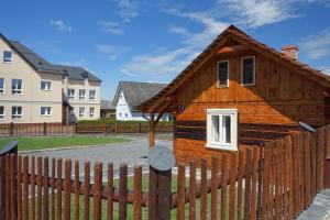 a small wooden house behind a fence at Roubenka u kostela 