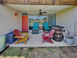 a patio with chairs and a table and a barrel at Sandy Shores in Port Aransas