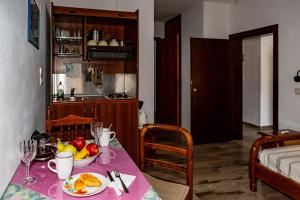 a kitchen with a table with a bowl of fruit on it at FRINI APPARTMENTS in Kokkari