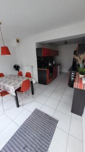 a living room with a table and red chairs at Apartament/Pietro domu in Charzykowy