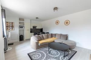 a living room with a couch and a table at Maisonnette 2 Un Séjour à Part in Longeville-lès-Metz +9 photos