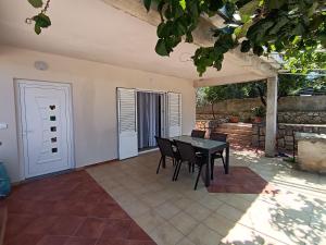 a dining room with a table and chairs in a patio at Apartmani Noel in Lun