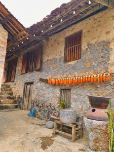 an old stone building with a grill in front of it at Triệu hoan homestay nhà sàn cổ tại làng đá cổ Khuổi ky in Dam Thuy