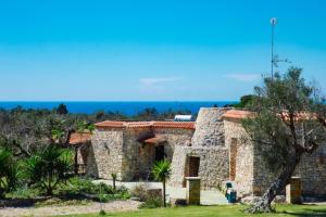 a stone building with the ocean in the background at Posto Cantoro in Marina di Pescoluse