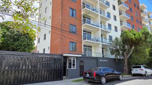 ein schwarzes Auto, das vor einem Gebäude geparkt ist in der Unterkunft Habitación en casa de Diana in San Salvador + 7 Fotos