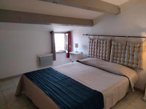 une chambre avec un grand lit et une fenêtre dans l'établissement Grand appart proche des plages Parking privé, à Saintes-Maries-de-la-Mer