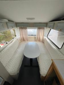 a small white table and chair in an rv at Koselig campingvogn in Bodø +1 photo