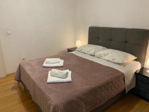 a bedroom with a large bed with towels on it at Apartman Toni in Bibinje