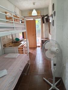 Una habitación con una cama, un escritorio y un ventilador. en StudioAretiCom Anogio with private Veranda In Front Of The Lovely Sea For Rent in Nea Plagia Chalkidiki Greece PlagiaStudiosEu, en Nea Plagia