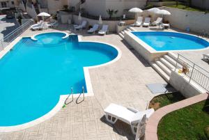 a large swimming pool with chairs and a swimming pool at Apartments Vista Muo 2026 NEWLY RENOVATED in Kotor