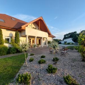 a house with a table and chairs in a yard at Pensjonat Poranna Rosa in Grabowiec