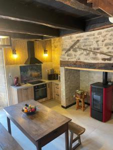 a kitchen with a table with a bowl of fruit on it at Chaumière du 16-ème siècles in Saint-Augustin