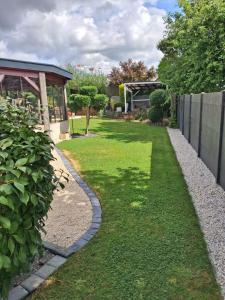 a garden with a stone walkway next to a fence at Villa Rosso in Clisson