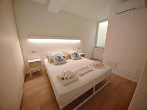 a small white room with a bed and a window at SG Luxury - Pieds dans l eau Torri in Torri del Benaco