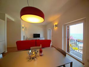 a living room with a table and a red couch at SG Luxury - Pieds dans l eau Torri in Torri del Benaco