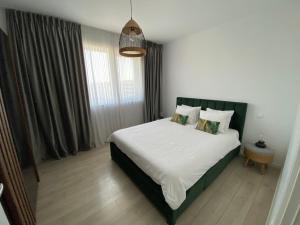 VoluntariにあるCozy Flat North Bucharestの白いシーツと枕が備わったベッドのある寝室