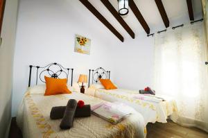 a bedroom with two beds with towels on them at Casa Carámbila in Cómpeta +46 photos