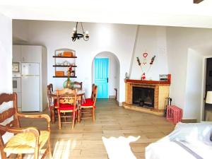 a kitchen and dining room with a table and a fireplace at Casa Carámbila in Cómpeta