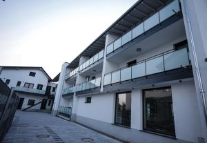 an external view of a white building with glass windows at Be Grand Apartments Rust in Rust