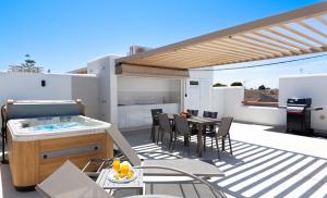 a patio with a hot tub and a table and chairs at Cactus Apartment La Ribera in Santiago de la Ribera