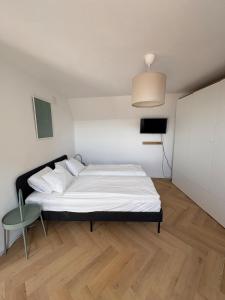 GrößingにあるCentrally located apartmentのベッドと椅子のある白い寝室