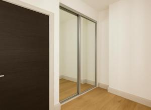 a sliding glass door in a room with white walls at Bright Studio Flat - Walk to River Thames & Kingston Town in Surbiton