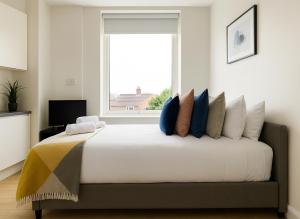 a bedroom with a large bed with a window at Bright Studio Flat - Walk to River Thames & Kingston Town in Surbiton