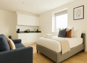 a bedroom with a large bed and a couch at Bright Studio Flat - Walk to River Thames & Kingston Town in Surbiton +19 photos