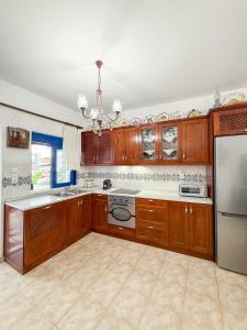a kitchen with wooden cabinets and a stainless steel refrigerator at Gennadi Traditional Aura in Gennadi